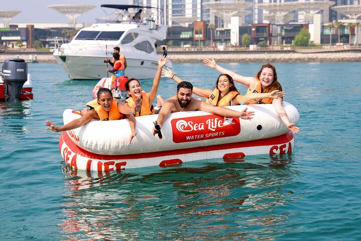 Experience the excitement of a donut ride in Dubai where laughter meets splashes as you glide across the water taking in stunning views of the coastline and sunset.